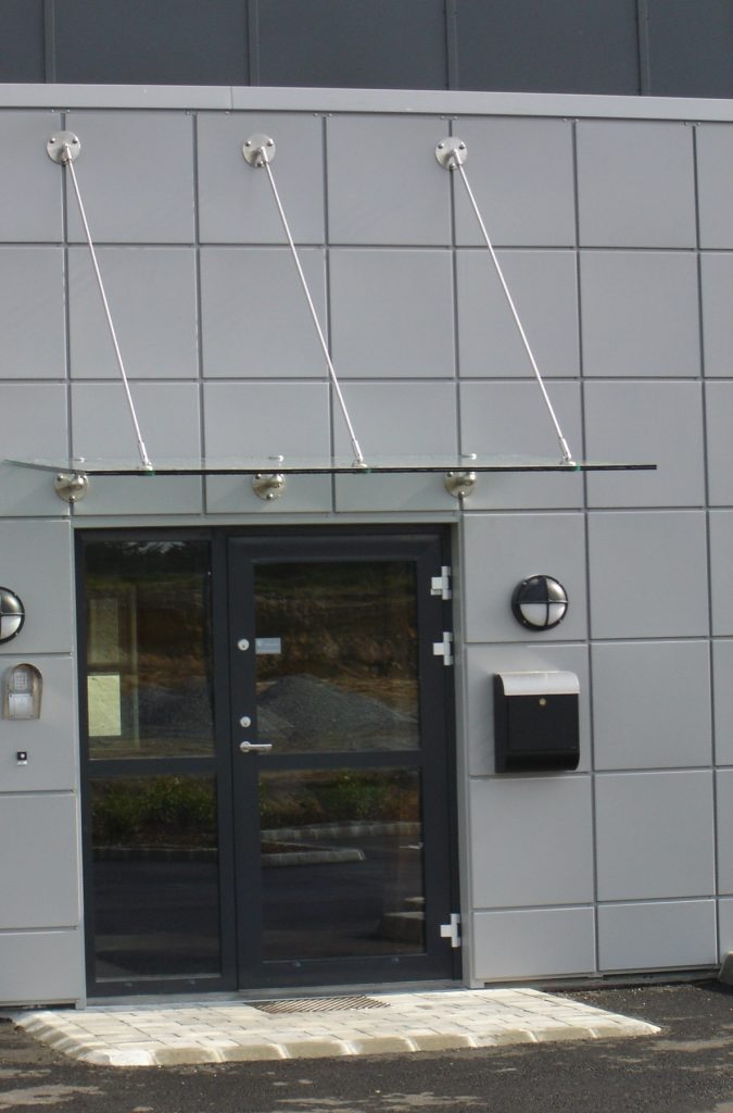 Glassbaldakin over inngang på kontorbygg på Forus